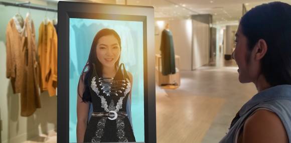 Frau vor Bildschirm mit virtueller Mode 