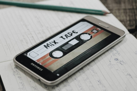 Symbolbild zeigt ein Smartphone, auf dessen Display eine Musikkassette mit der Aufschrift "Mix Tape" zu sehen ist 