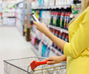 Frau im Supermarkt mit Smartphone 