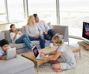 Familie schaut fernsehen, kinder spielen nebenbei am Smartphone oder Tablet 