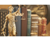 Justitia-Figur vor Gesetzbüchern