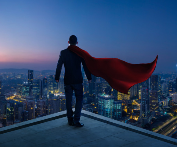 Businessman mit Cape und Stadt im Hintergrund 