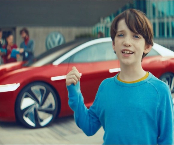Junge zeigt auf ein rotes Auto 