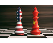 Zwei Schachfiguren mit Flaggen von den USA und China