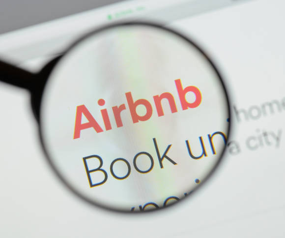 Logo von Airbnb durch eine Lupe 