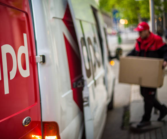 Mann trägt Paket in ein Auto 