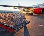 Kartons stehen vor einem Flugzeug