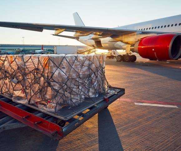 Kartons stehen vor einem Flugzeug 