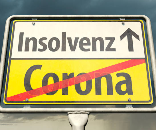 Corona und Insolvenz steht auf einem Straßenschild Corona und Insolvenz steht auf einem Straßenschild