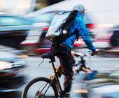 Fahrradbote im belebten Stadtverkehr