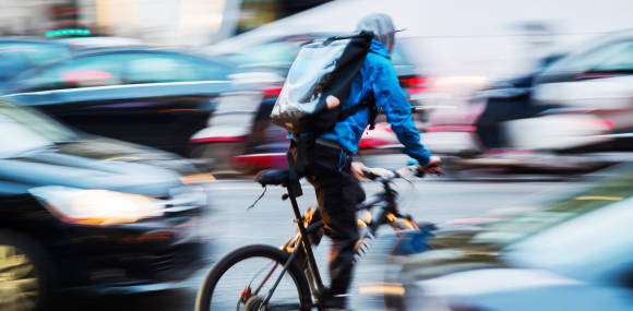 Fahrradbote im belebten Stadtverkehr 