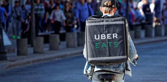 Fahrradfahrer mit Uber Eats Lieferung 