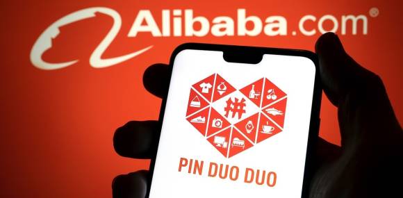 Pinduoduo Logo auf Smartphone, im Hintergrund Alibaba Logo 