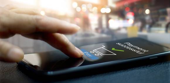 Hand vor Smartphone-Screen, der Zahlungsbestätigung anzeigt 
