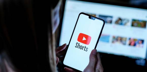 Person hält Smartphone mit Youtube Shorts App Logo 