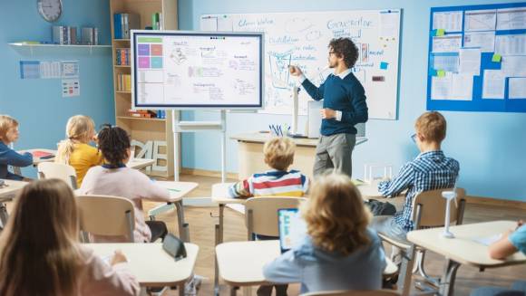 Lehrer zeigt auf Whiteboard 