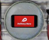 Delivery Hero App auf Smartphone auf Teller 
