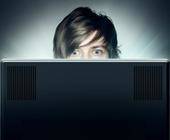 Person schaut mit grossen Augen auf einen Monitor