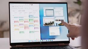 Hand zeigt auf einen Notebook-Bildschirm mit Windows 11 