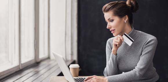 Frau mit Kreditkarte am Laptop 