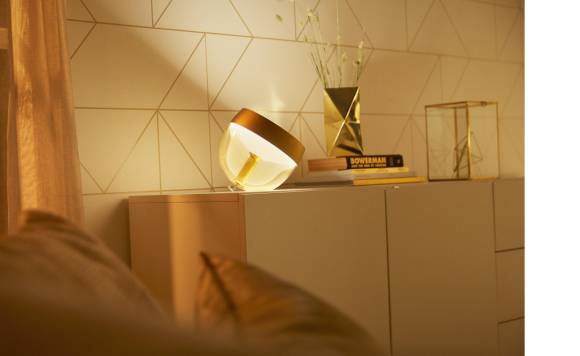 Das Foto zeigt ein Schlafzimmer; auf dem Nachttisch steht die Lampe Iris von Hue