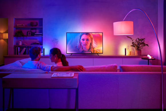 Das Foto zeigt einen Fernseher, der von einer farbigen Aura umgeben ist, die die Farben des Bildes widerspiegelt