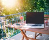 Balkon mit Laptop auf Holztisch