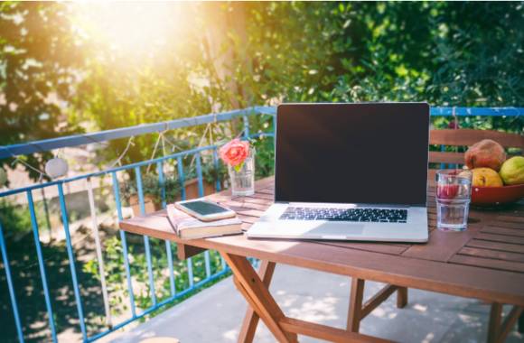 Balkon mit Laptop auf Holztisch 