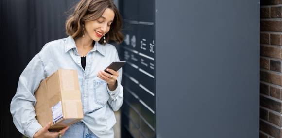 Frau holt Paket ab an Abholstation 