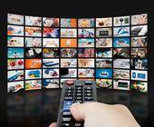 Ein Curved-Smart-TV voller Vorschaubilder von Sendungen