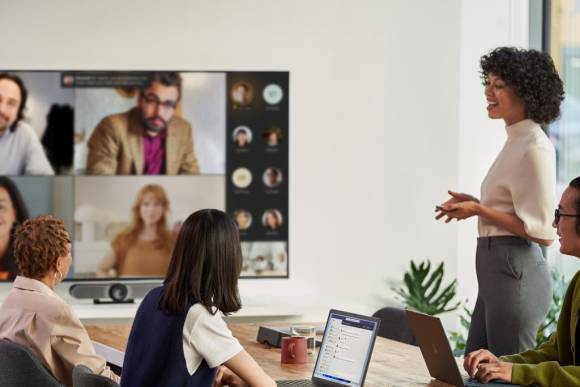 Hybrides Teams-Meeting mit im Sitzungszimmer sowie per TV-Bildschirm anwesenden Personen 