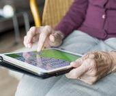 Tablet mit Händen einer alten Frau