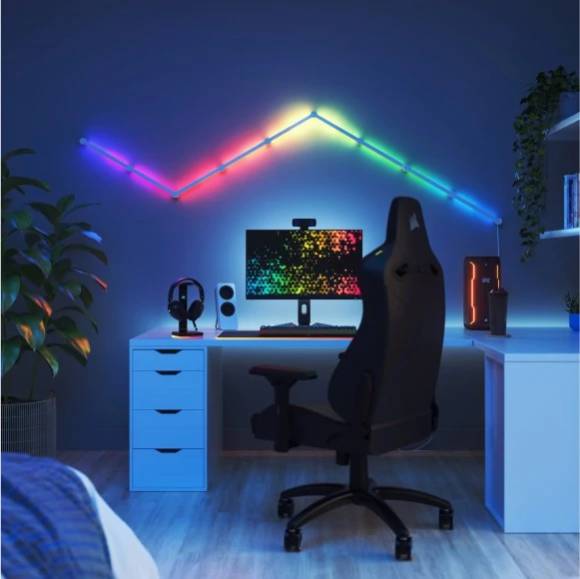 Eine gezackte Linie aus Nanoleaf-Leuchtelementen leuchtet an einer Wand in Regenbogenfarben 