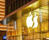 Symbolbild zeigt Apple-Logo an einer gläsernen Gebäudefassade