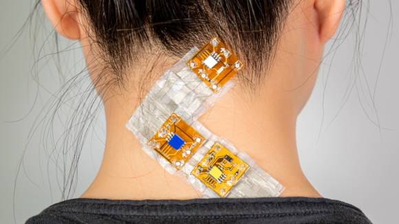 Chips und Sensoren kleben in einer Art Pflaster am Nacken einer Probandin 
