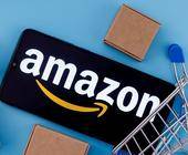 Amazon-Schriftzug auf einem Smartphone mit Paketen