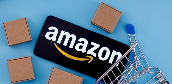 Amazon-Schriftzug auf einem Smartphone mit Paketen 