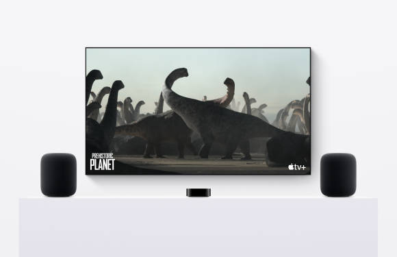 Ein Fernseher mit Apple TV, der von zwei HomePods flankiert wird