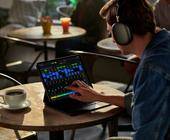Ein Musiker sitzt in einem Kaffee vor dem iPad Pro, auf dem die App Logic Pro läuft
