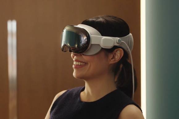 Eine Frau trägt eine Vision Pro, die etwas wie eine verkabelte Taucherbrille aussieht 