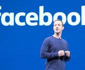 Mark Zuckerberg steht vor einer Wand mit Facebook-Logo