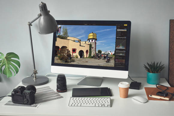 Ein iMac und eine Kamera auf einem Schreibtisch 