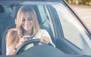 Autofahrerin mit Handy im Auto 