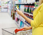 Frau im Supermarkt mit Smartphone