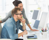 Mann und Frau vor PC im Büro