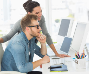 Mann und Frau vor PC im Büro 