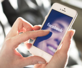 Frau surft auf Facebook am Smartphone