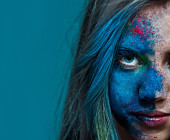 Frau mit Farbspritzern im Gesicht