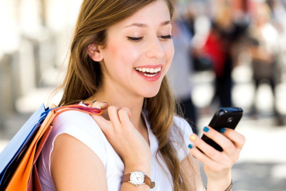 Frau mit Shopping-Tasche und Smartphone 