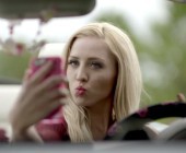 Blonde Frau macht Selfie im Auto